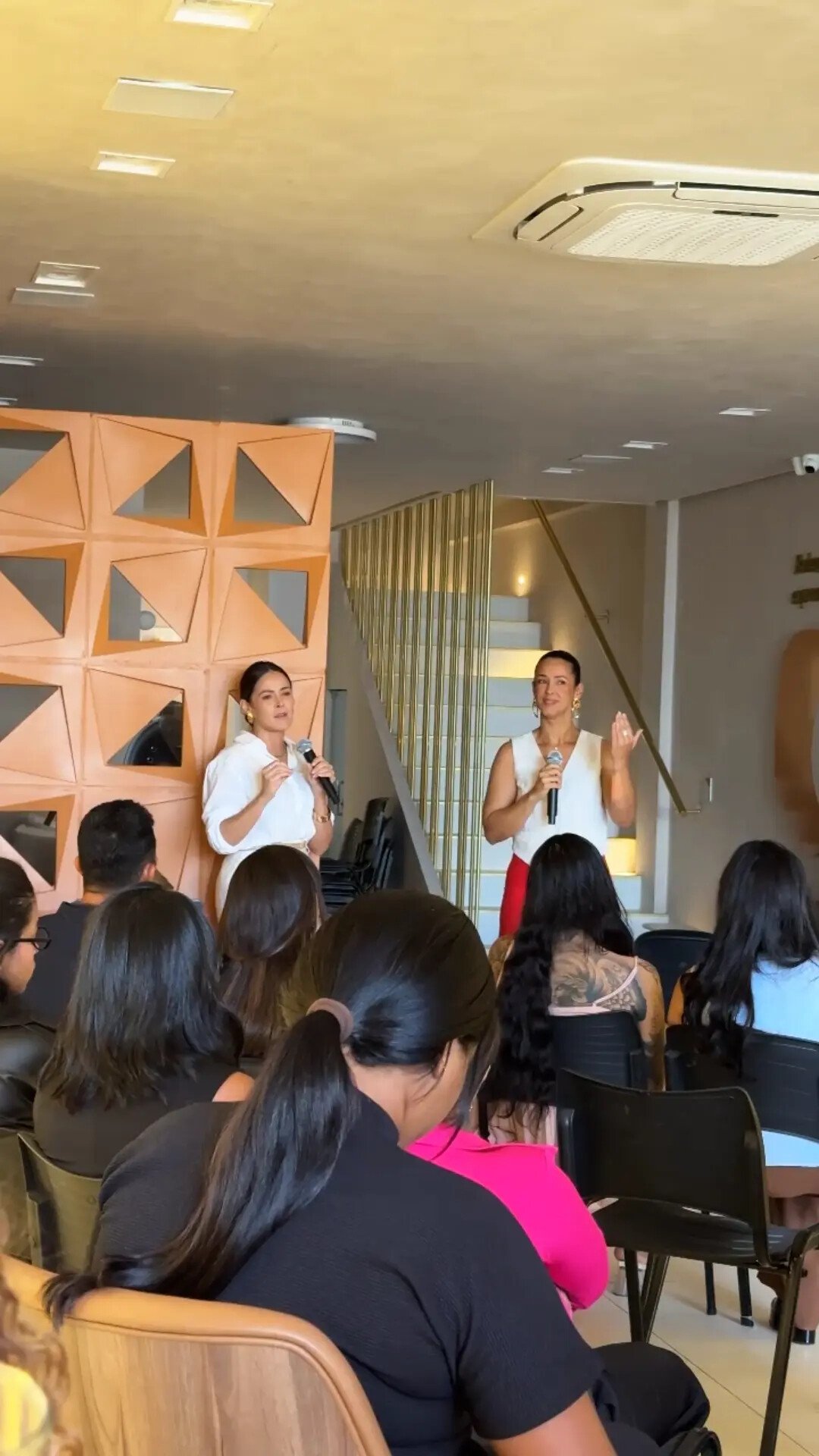 Lívia e Patrícia Suzarte falando para participantes em um treinamento